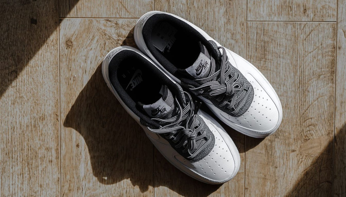 Paire de baskets blanches à avant-pied large, posées sur un plan de bois clair